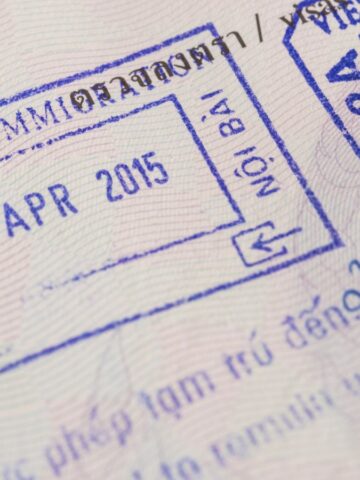 Close-up of a passport page with blue Vietnam immigration entry and exit stamps dated 22 April 2015, offering visa insights for travel planning. Text in Vietnamese and English is visible around the stamps.