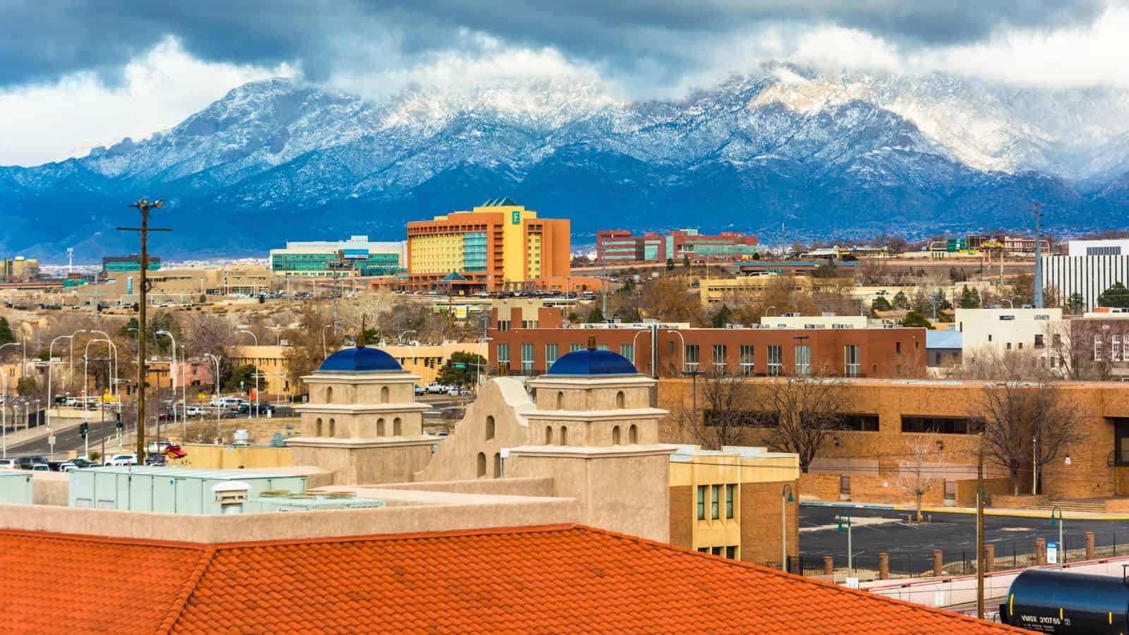 City buildings with red-tiled roofs stand on the brink, set against mountains and cloudy skies—a scene echoing concerns about the water crisis faced by many U.S. cities today.