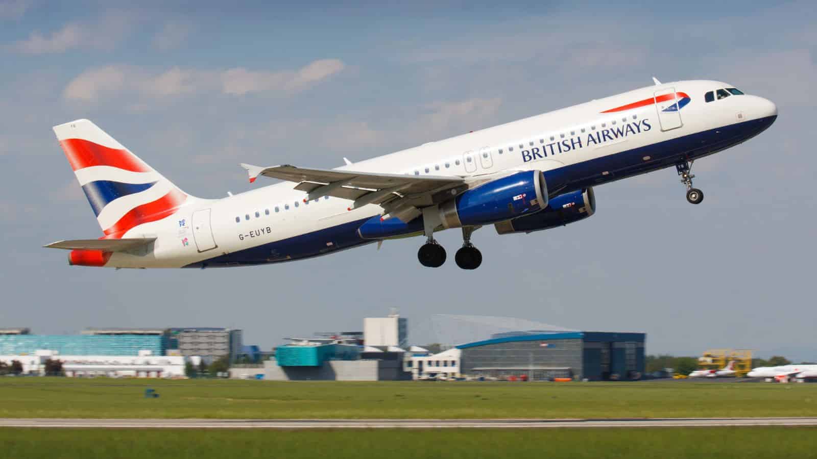 A British Airways airplane taking off from a runway, with airport buildings in the background.