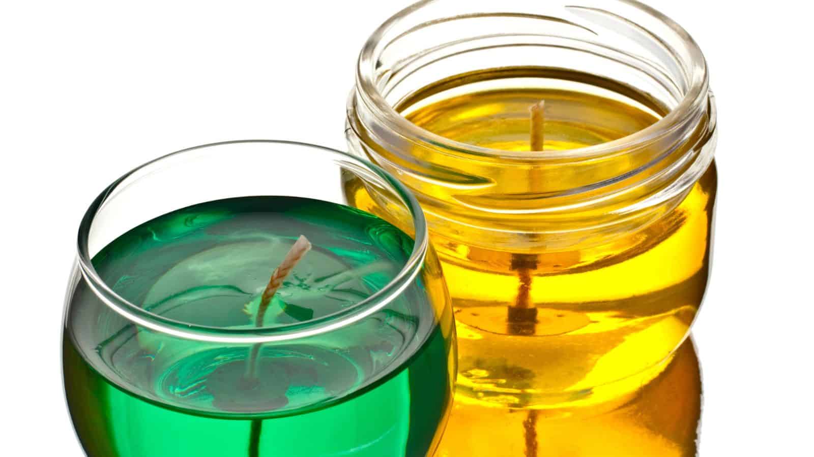 Two glass containers, one with green gel and one with yellow gel&mdash;resembling decorative candles&mdash;are placed side by side on a reflective surface, similar to unusual confiscated items sometimes seen by TSA agents at airport security.