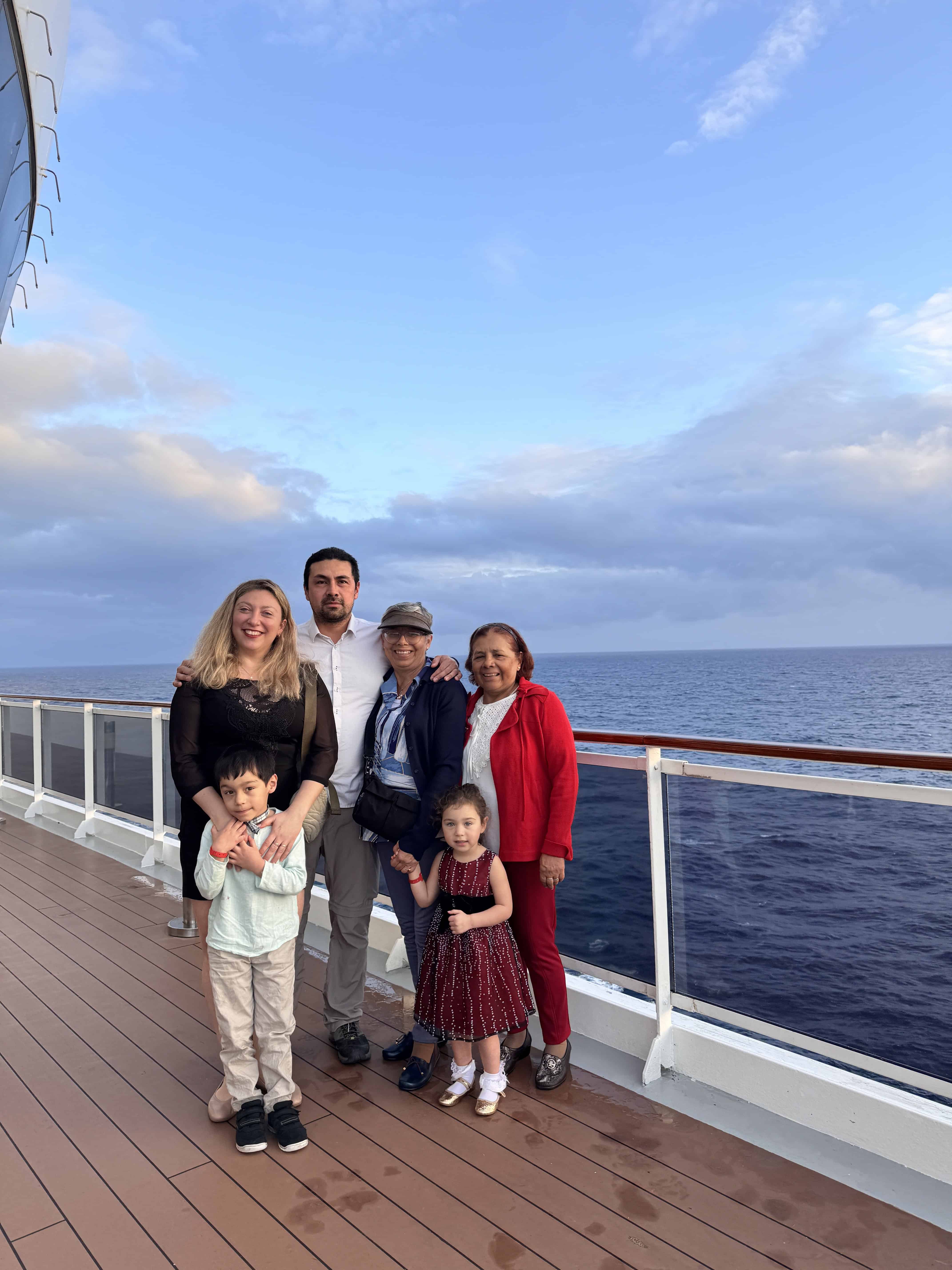 Six people posing together on the deck of the MSC Cruise Fantasia, with the ocean and blue sky in the background.