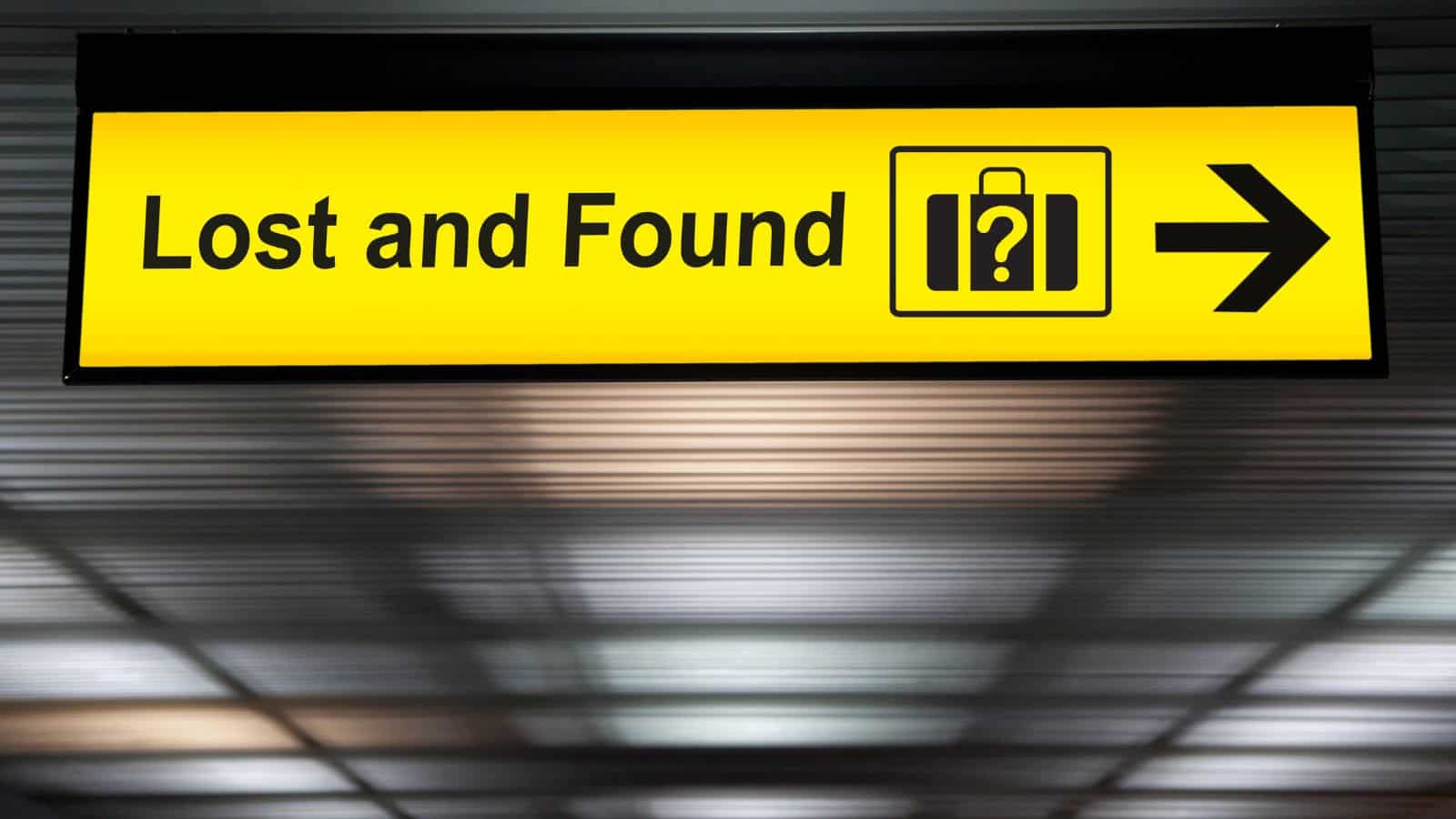 A yellow sign with black text reading "Lost and Found" and a suitcase icon with a question mark guides travelers to the area where commonly lost items in U.S. airports can be retrieved. A black arrow on the right points toward the lost and found area.