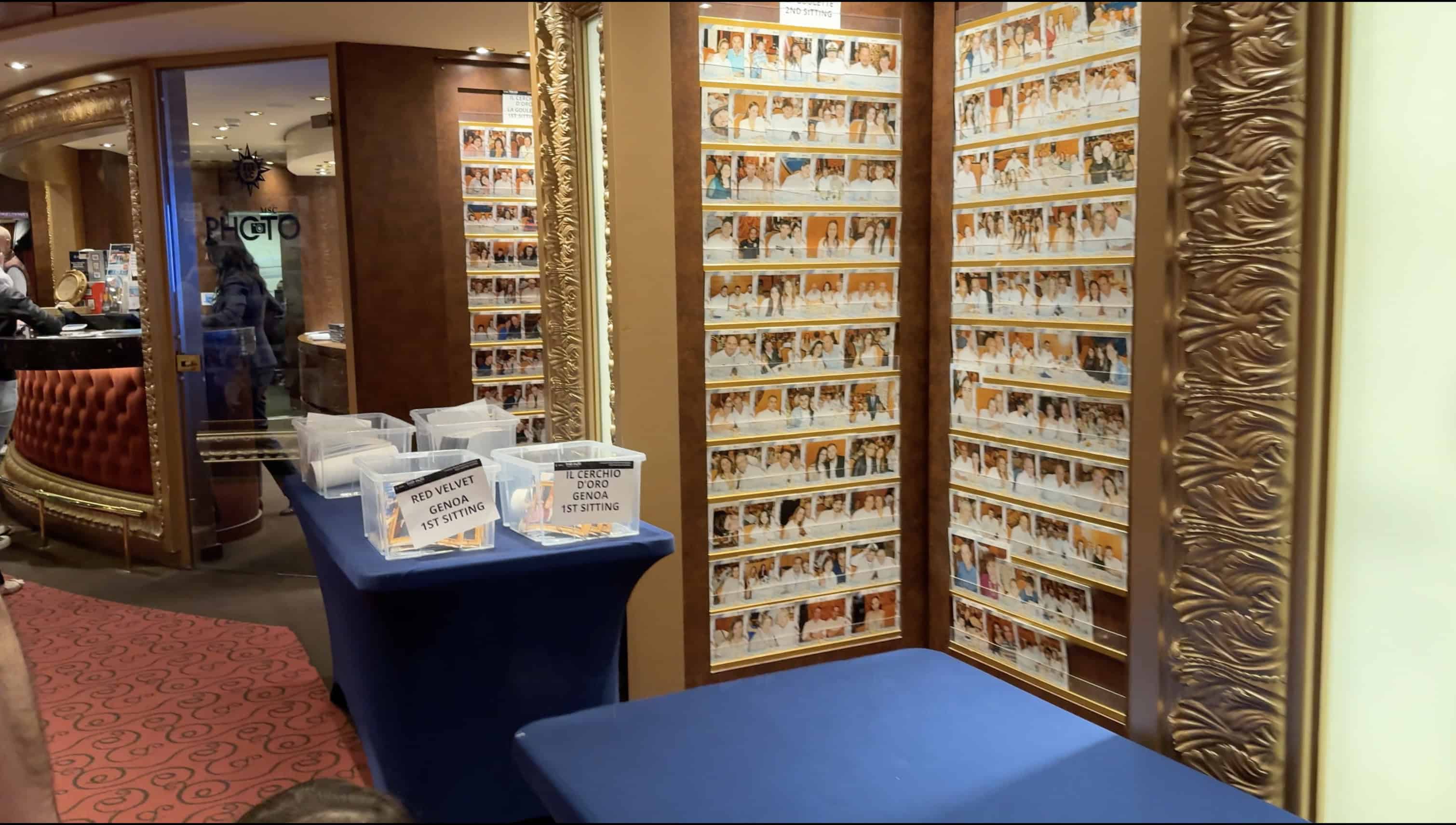 Photographs displayed on a wall with bins on tables labeled for event photo sorting and viewing, perfect for guests to relive their 2025 MSC Fantasia voyage or leave a Cruise Review.