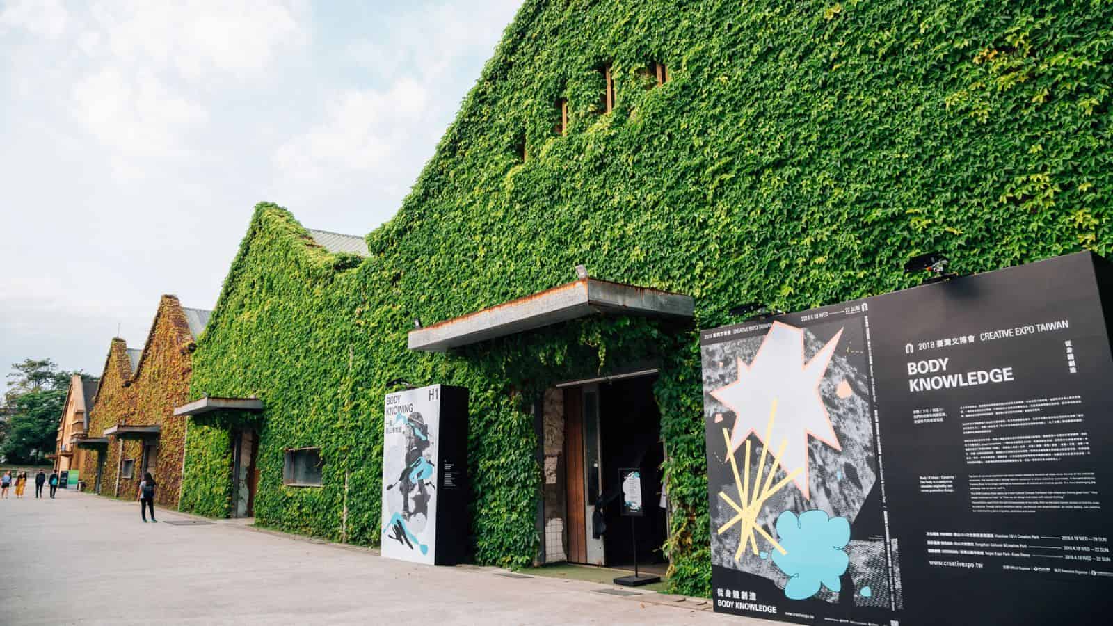 Ivy-covered buildings with exhibition signs outside on a bright, clear day.