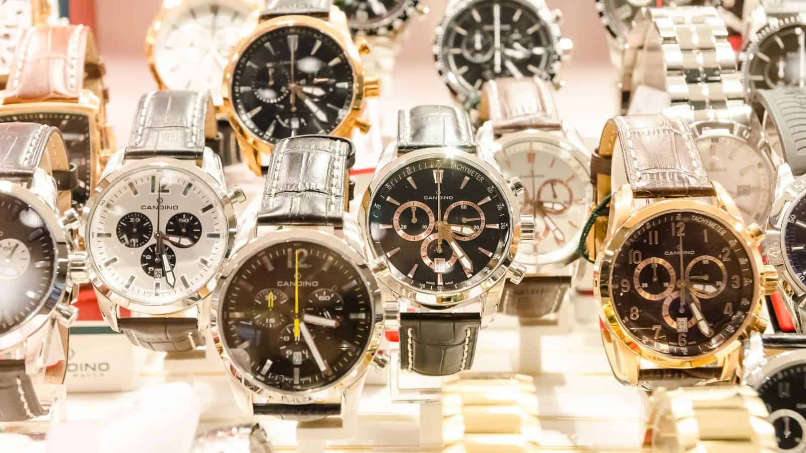 A display of assorted men's wristwatches with various designs and colors, arranged in rows.