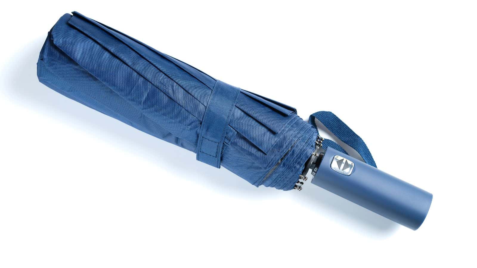 Closed blue umbrella with a wrist strap, lying on a white background.