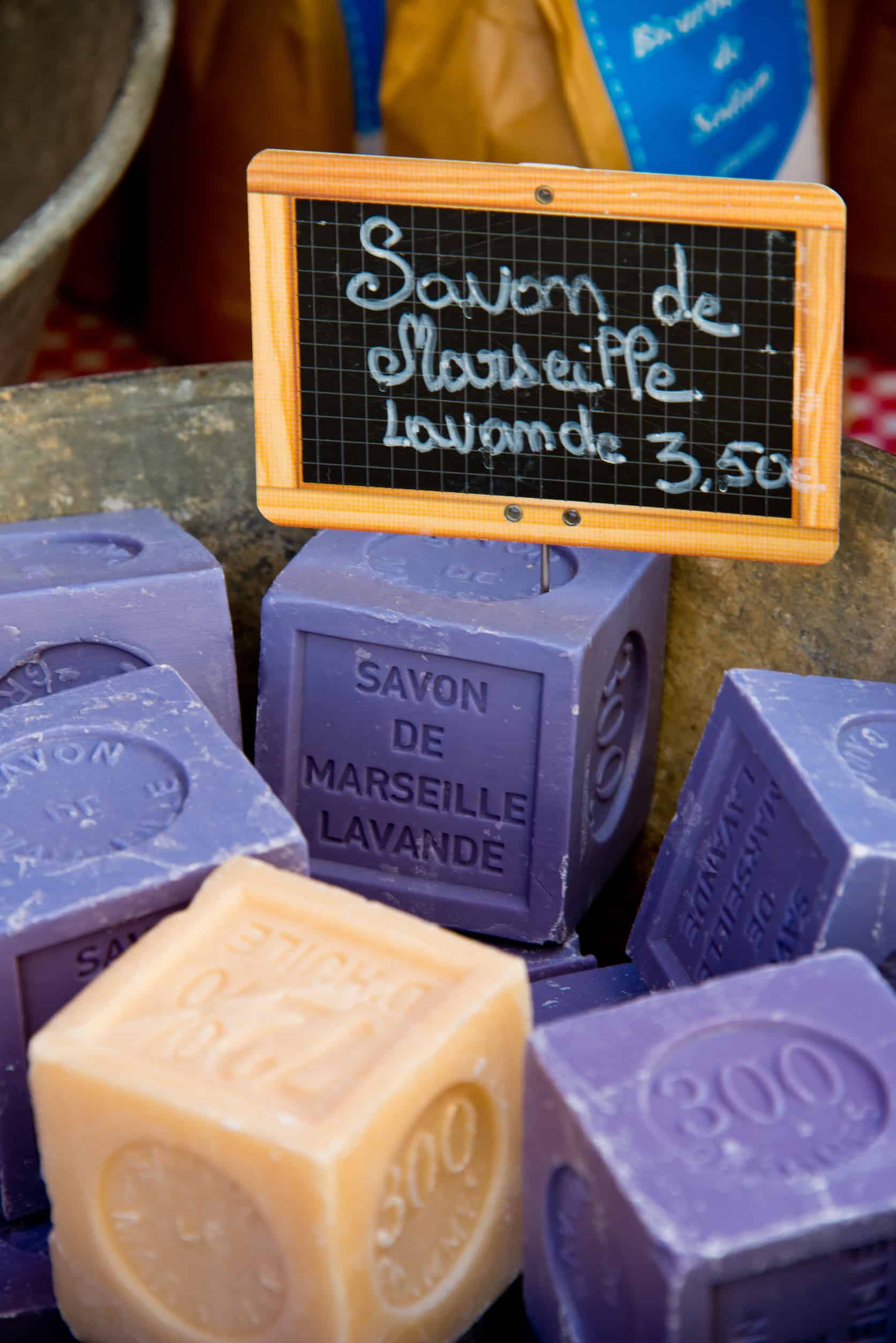 Cubes of lavender Marseille soap with a sign reading "Savon de Marseille Lavande 3,50€" in French—an authentic souvenir from any itinerary through France.