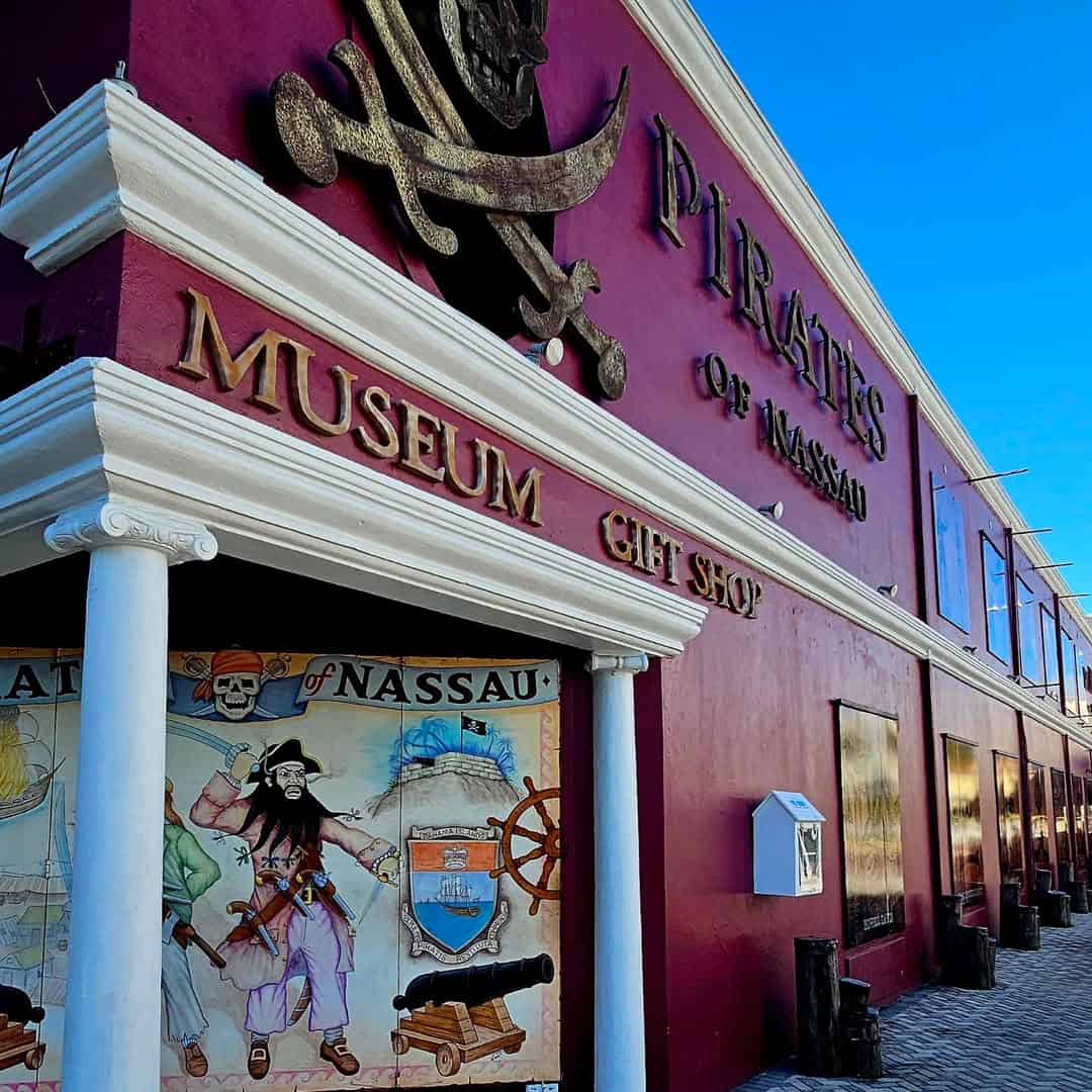 Pirates of Nassau Museum exterior with pirate mural, large sign, gift shop entrance, and blue sky above—an ideal stop for Bahamas Cruise Activities for Families.