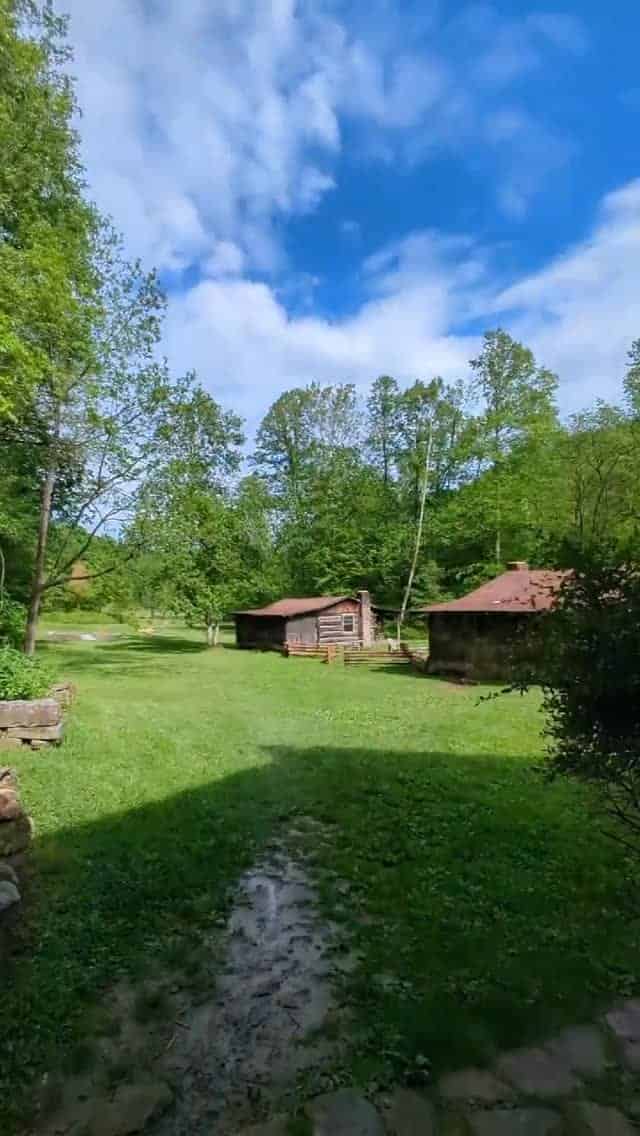 A log cabin in a grassy area, perfect for those seeking the best mountain getaways.
