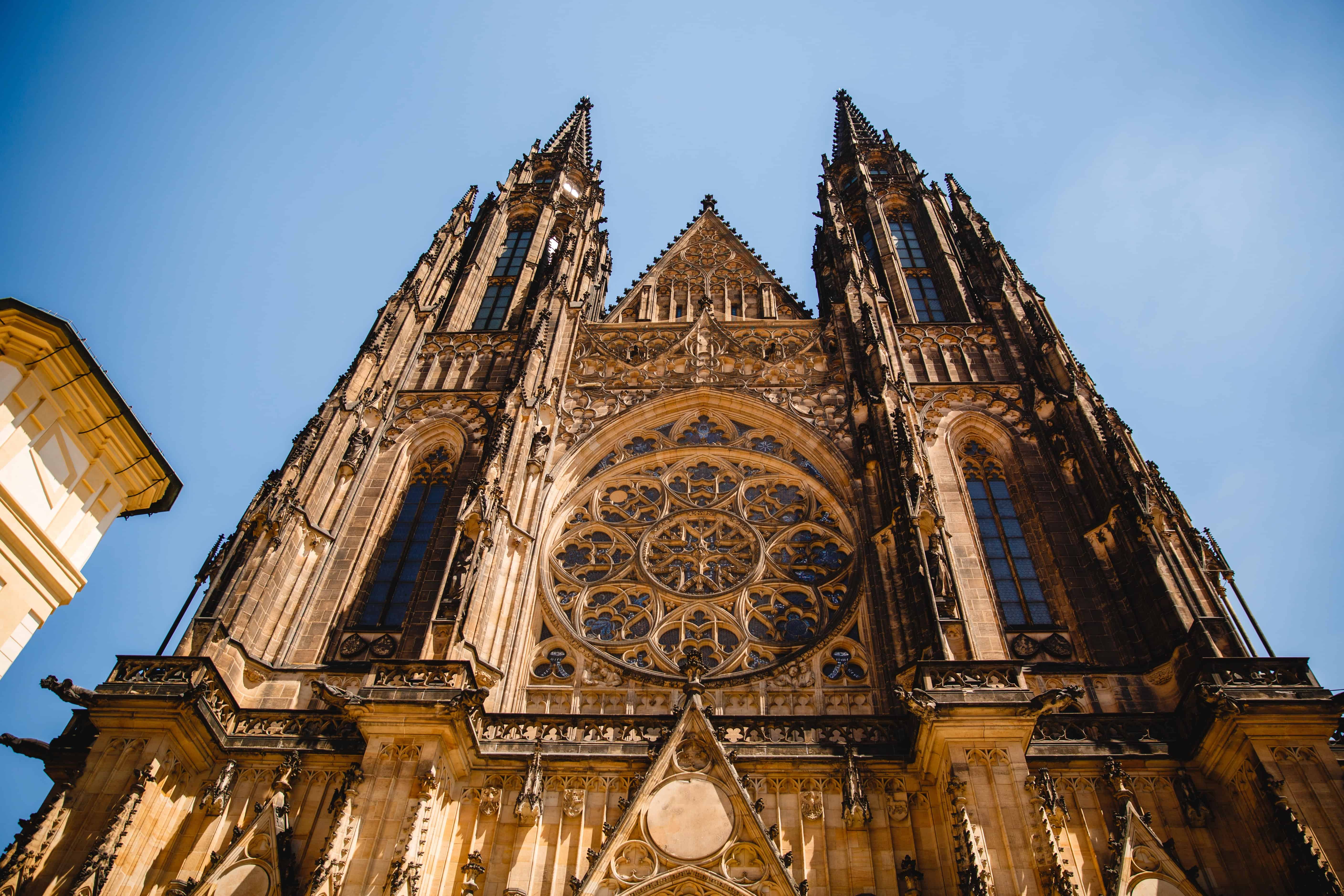 Gothic cathedral facade with twin spires, ornate stonework, and a large rose window against a blue sky—an iconic landmark often listed among haunted places in Europe.