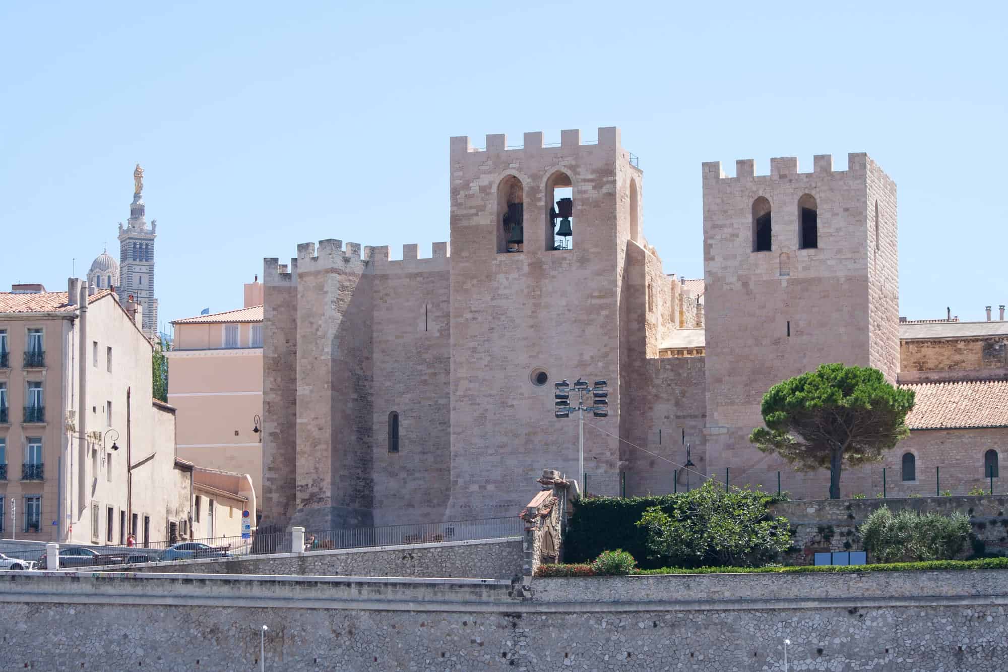 Sand-colored medieval fortress with square towers and battlements, set against a clear blue sky—an essential stop on any Marseille itinerary in France.