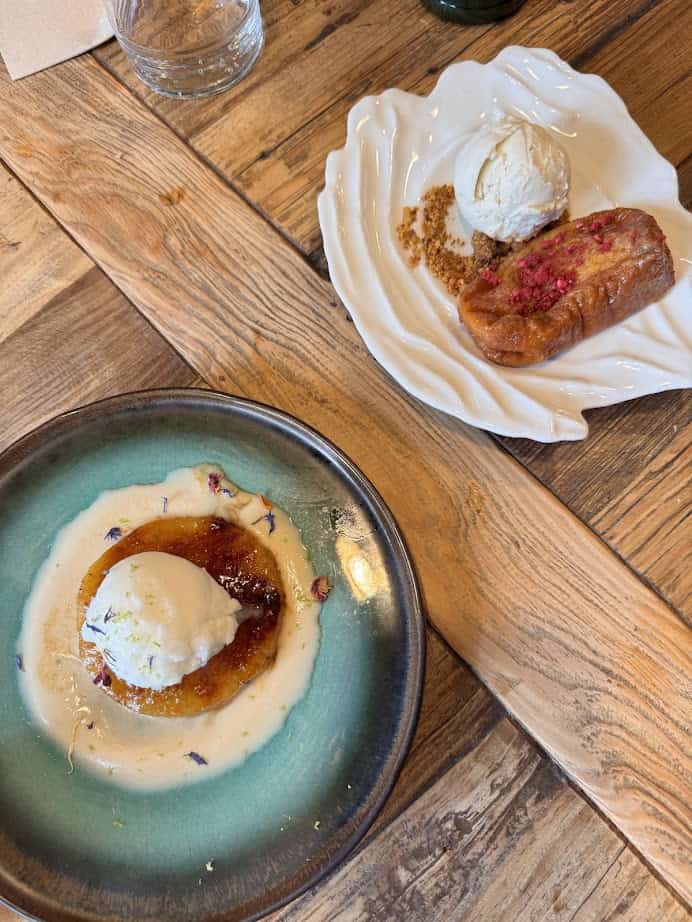 Two plated desserts with ice cream, served on a rustic wooden table—perfect inspiration for where to eat and find fresh food after exploring Barcelona markets.