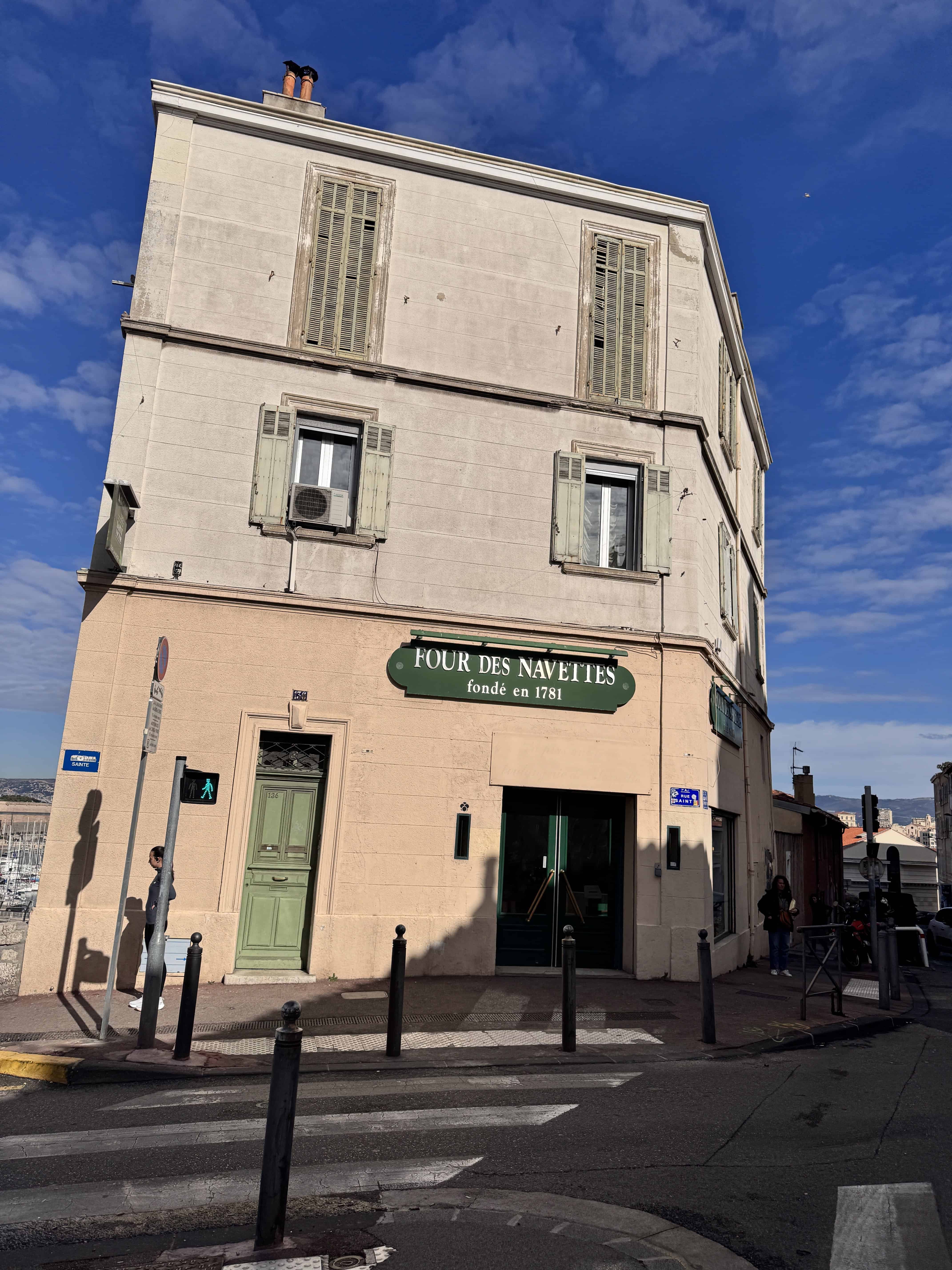 A beige corner bakery with green doors and shutters in Marseille, "Four des Navettes" sign above the entrance—an essential stop on any France itinerary.