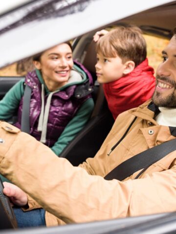 A family of three inside a car.