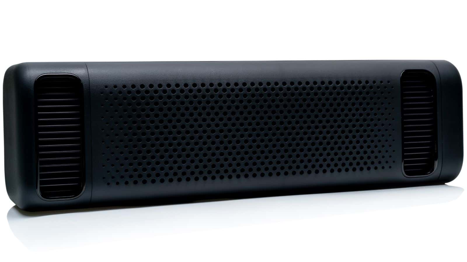 A black rectangular wireless speaker with perforated front and rounded edges on a white background.