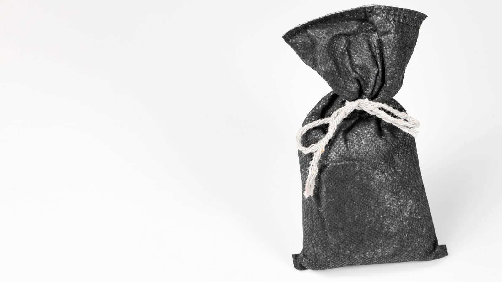 A black fabric bag tied with a white string, placed against a white background.