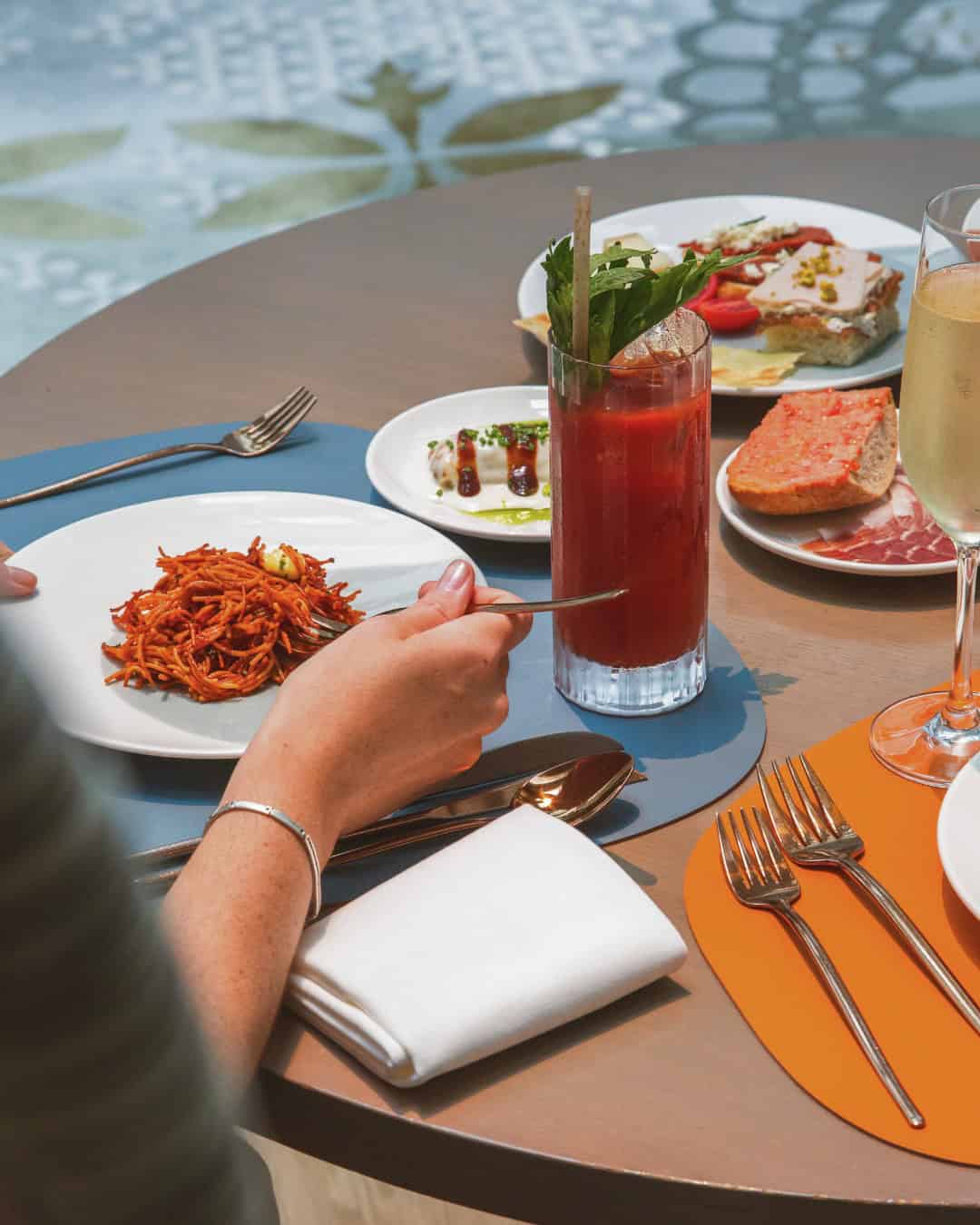 Savoring pasta at a table with a Bloody Mary, wine, bread, and assorted appetizers&mdash;just another memorable meal at one of the best restaurants Barcelona has to offer.