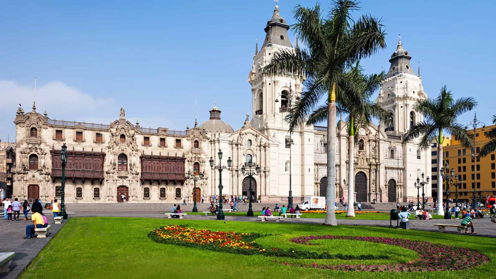 A vibrant plaza with gardens and people, surrounded by historic colonial buildings and a two-towered cathedral under a blue sky—one of the best places to visit for travel lovers exploring cities.