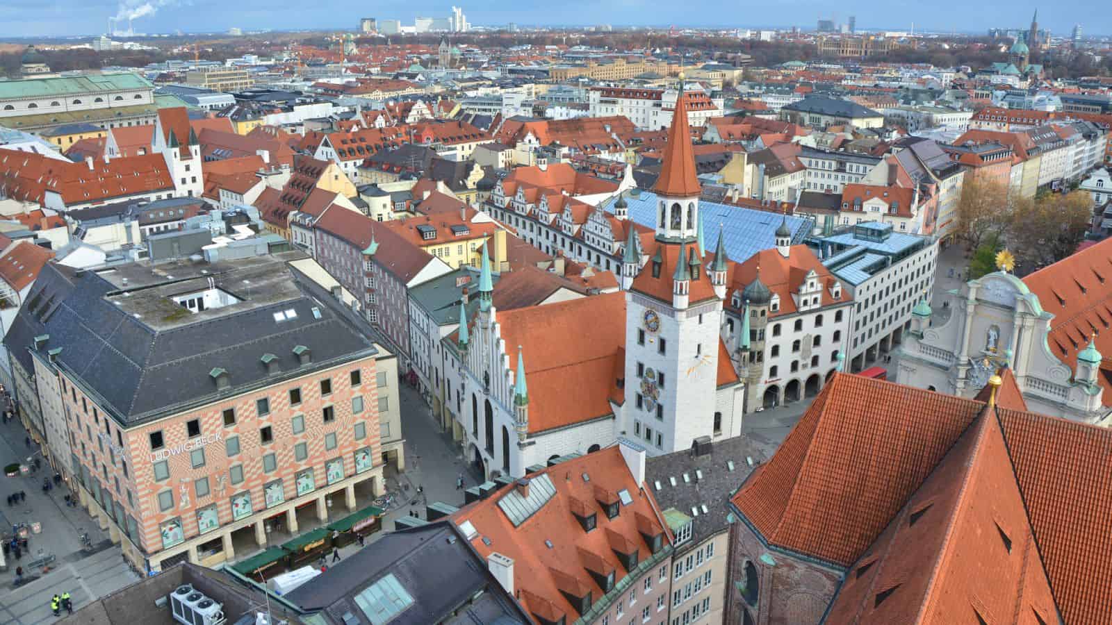 Aerial view of a European city with red-roofed buildings and church towers on a clear day.