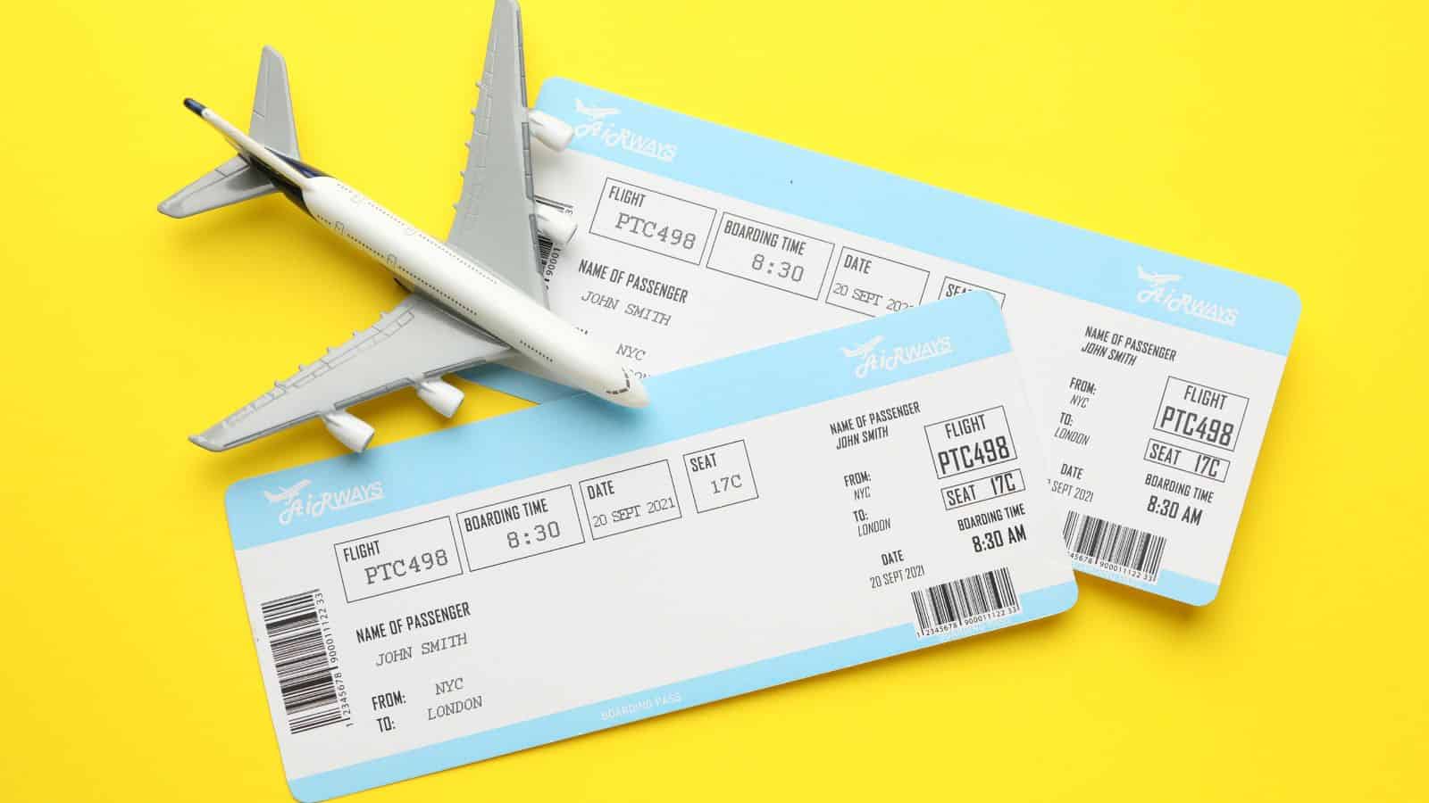 Two airline boarding passes and a toy airplane on a yellow background.