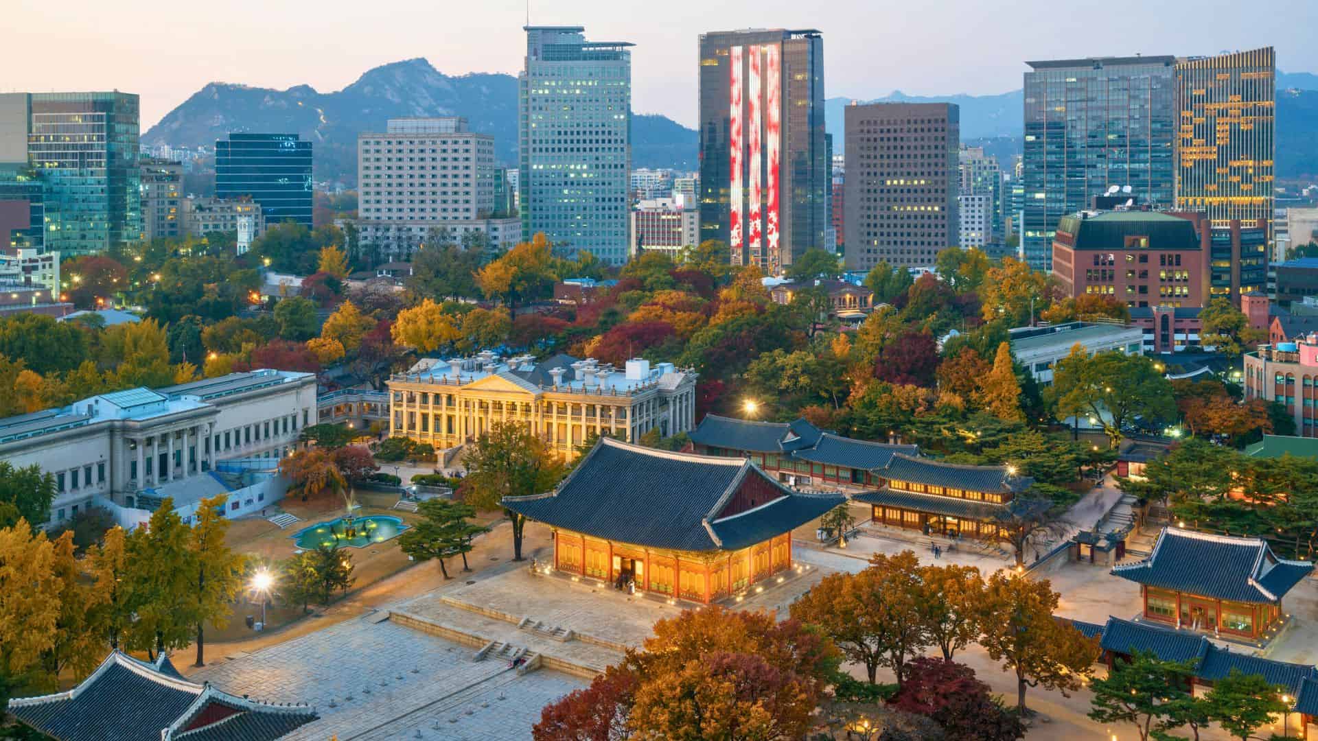 Aerial view of Deoksugung Palace with modern skyscrapers in Seoul, South Korea, during autumn.