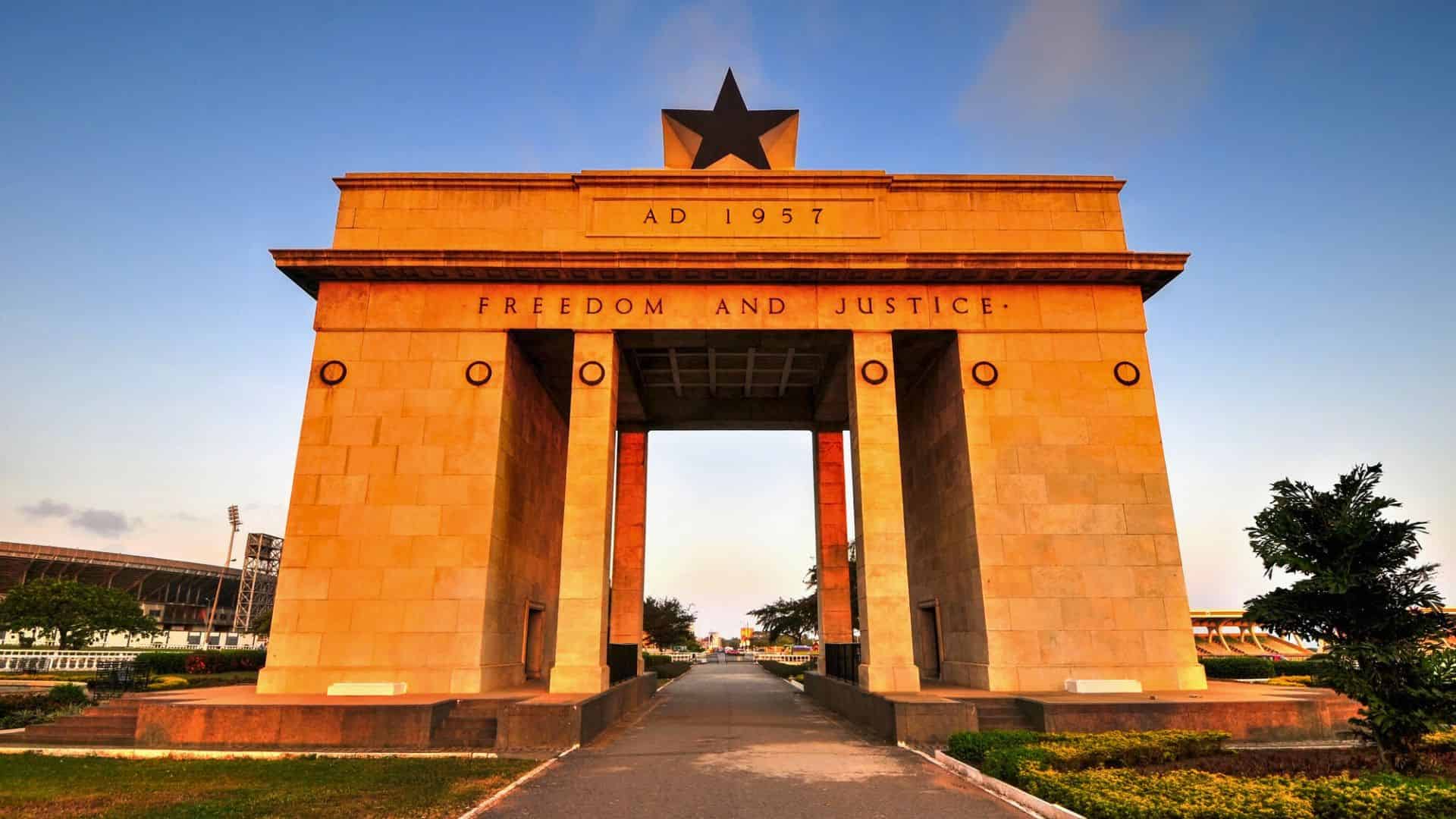 The Independence Arch in Accra, Ghana, with "Freedom and Justice" inscribed on it at sunset.