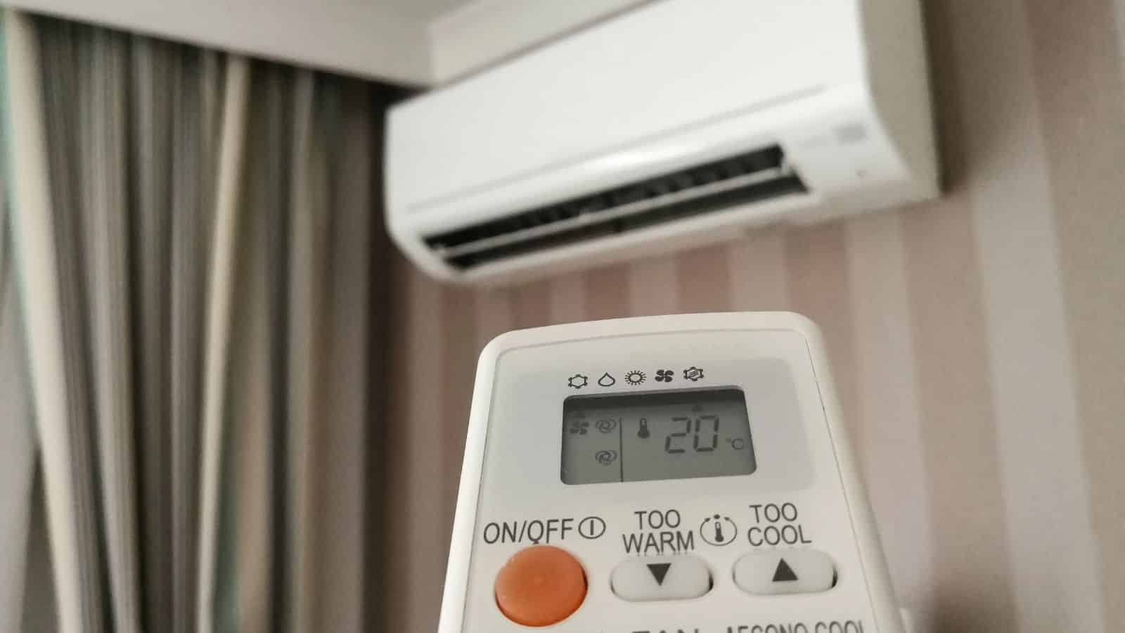 A remote control set to 20&deg;C pointed at a wall-mounted air conditioner in a room&mdash;perfect for over 35 travelers ticking off their hotel checklist.