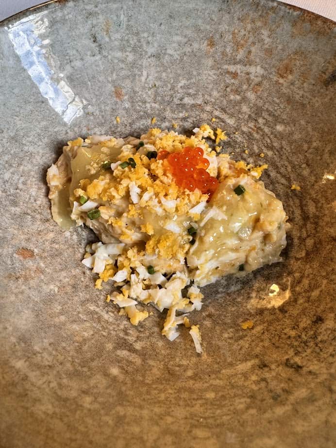 Mashed potatoes topped with chopped egg, chives, and orange fish roe in a rustic bowl&mdash;perfect comfort food after exploring the best things to do in Barcelona or following your 4 days in Barcelona itinerary.