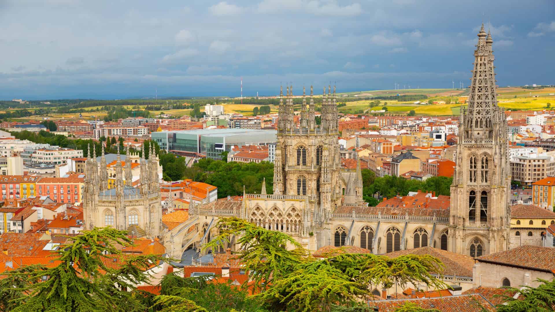 A large stone building with towers and red roofs.