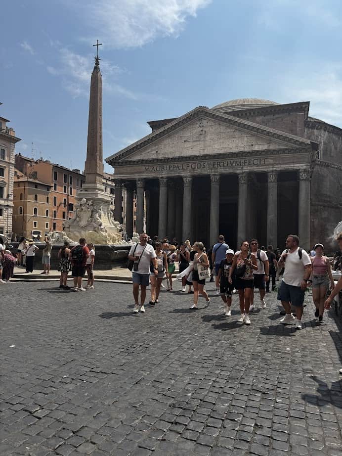Tourists gather in front of the Pantheon and an obelisk fountain on a sunny day in Rome, making it a perfect spot to include in your Family Itinerary when exploring Rome with kids.