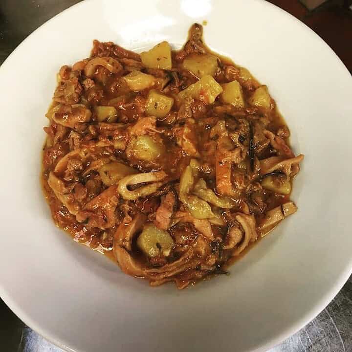 Stew with chunks of potato, meat, and vegetables in a thick, reddish-brown sauce, this Florence food favorite is served piping hot in a white bowl.