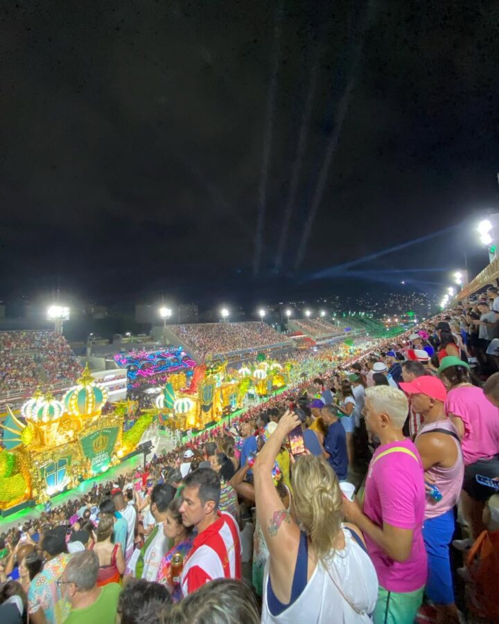 Crowds watch a vibrant parade with colorful floats and lights at one of the best winter festivals, creating a magical nighttime carnival celebration.