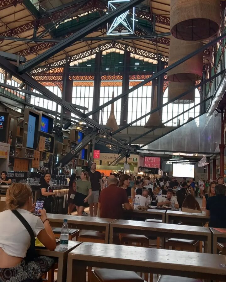 Large indoor food hall in Florence, Italy, with people eating, high ceilings, exposed beams, and natural light streaming in&mdash;a must-see on any Florence Italy itinerary.