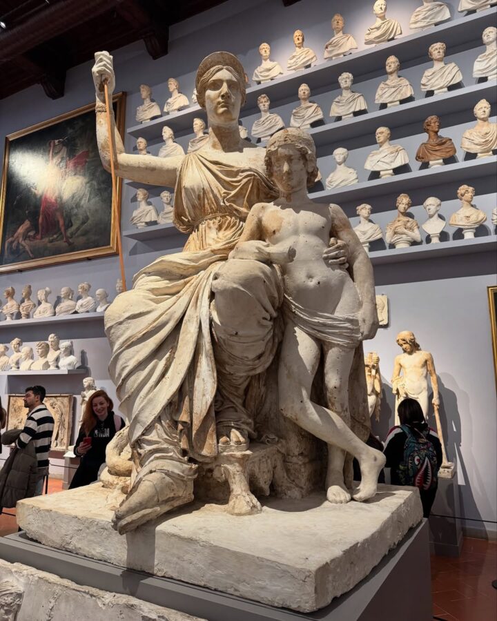 Large marble statue of a seated woman with a staff beside a standing child, surrounded by busts&mdash;an iconic highlight to include on your Florence Italy itinerary.