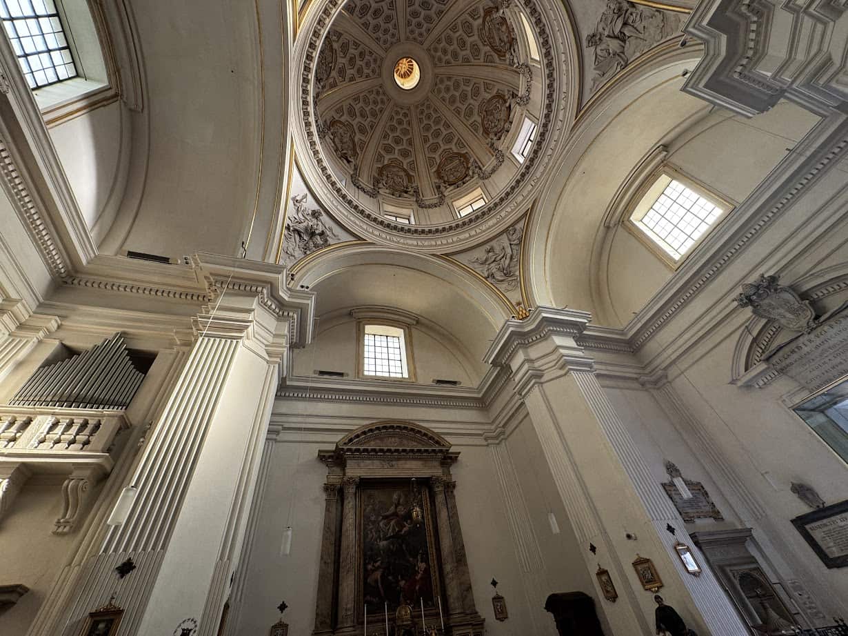Interior of a church in Castel Gandolfo with an ornate dome ceiling, large windows, and an altar adorned with religious artwork—a stunning sight during your 4 days in Castel Gandolfo.