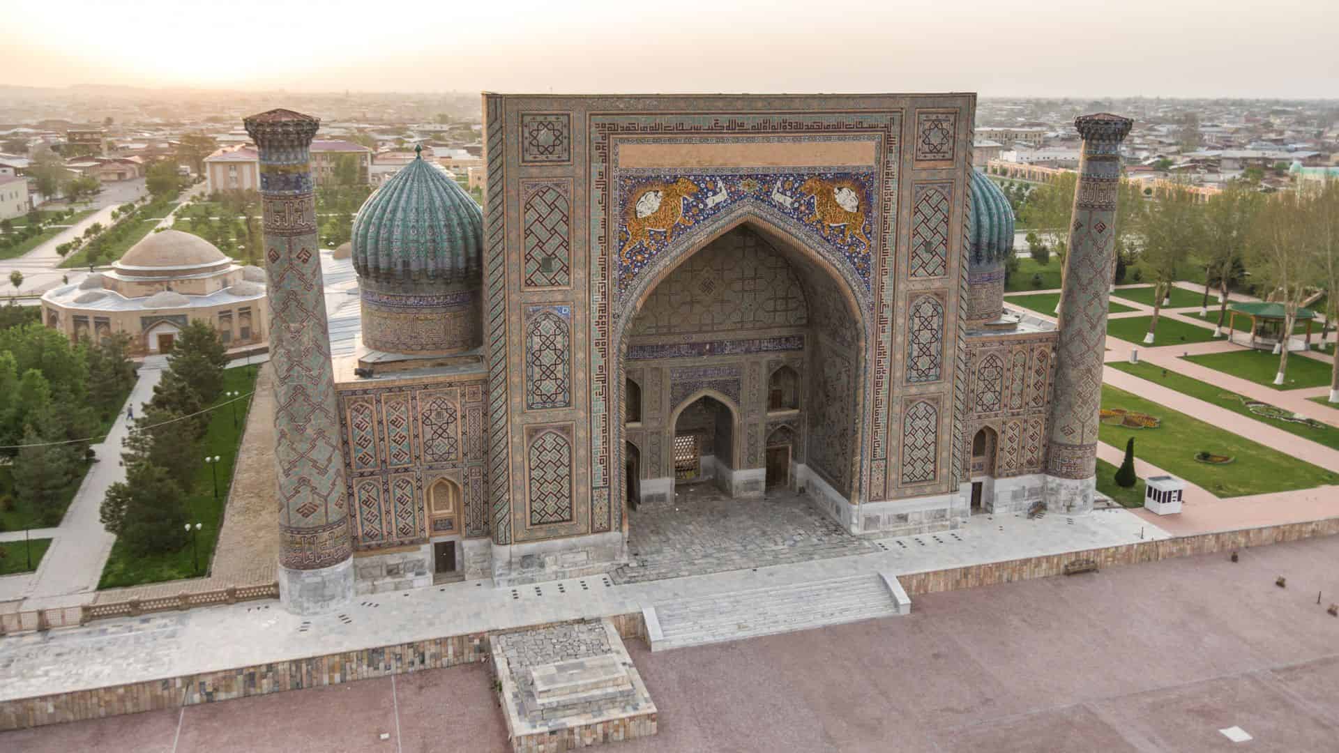 Aerial view of the ornate Registan madrasa in Samarkand, Uzbekistan, with domes and intricate tilework.