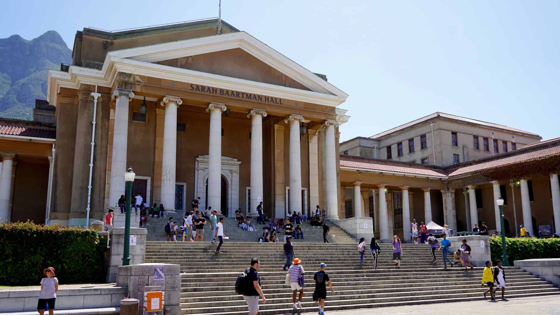 People walk up the steps to Sarah Baartman Hall at the University of Cape Town on a sunny day.