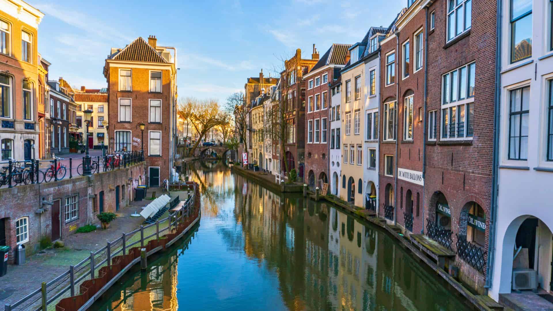 A peaceful canal lined with historic buildings and reflections in Utrecht, Netherlands.