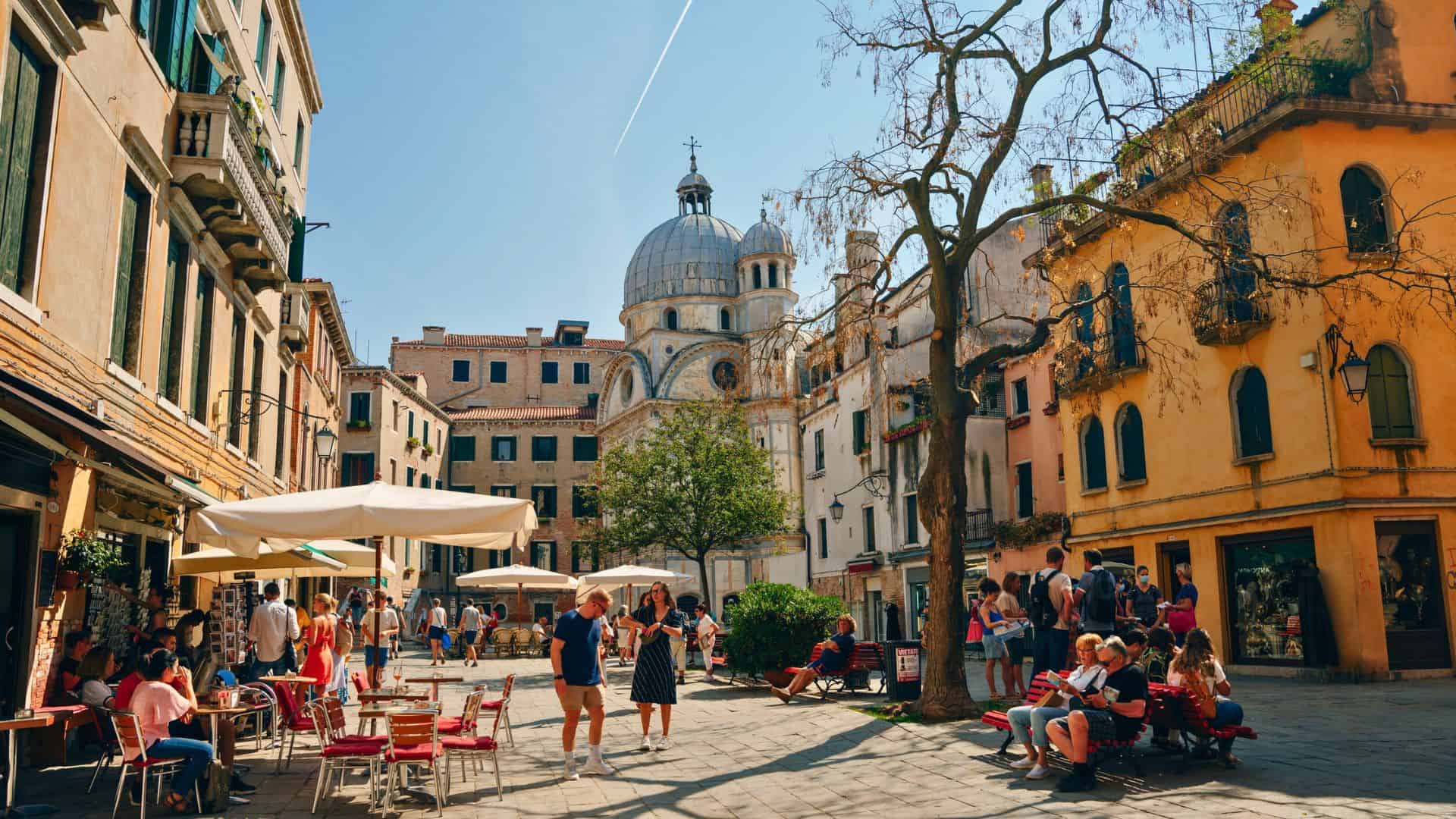A group of people sitting on benches in a courtyard.