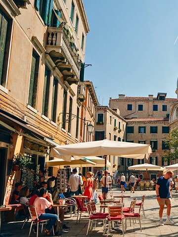 A group of people sitting on benches in a courtyard.