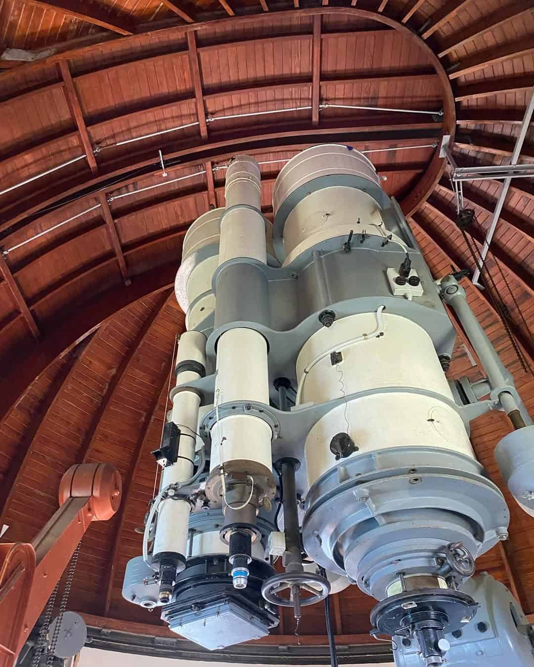 A large vintage telescope inside a wooden-domed observatory, viewed from below—an inspiring sight reminiscent of stargazing during 4 days in Castel Gandolfo.
