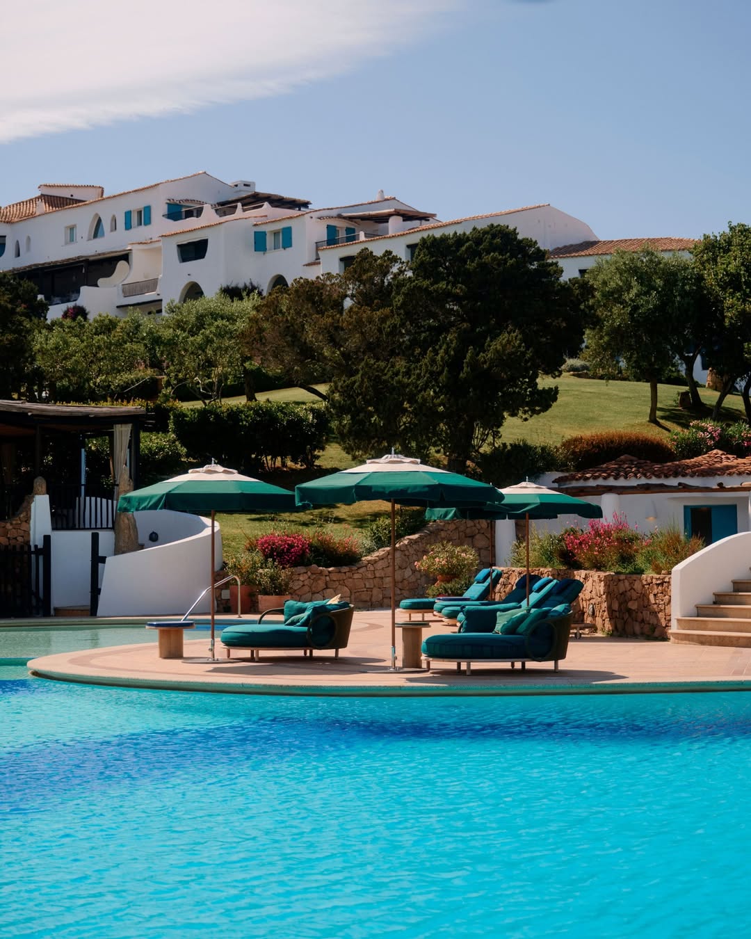 Enjoy a luxury pool with loungers and green umbrellas, surrounded by gardens and white buildings&mdash;just what you&rsquo;d expect from one of the best beach resorts in Italy for families on a sunny day.