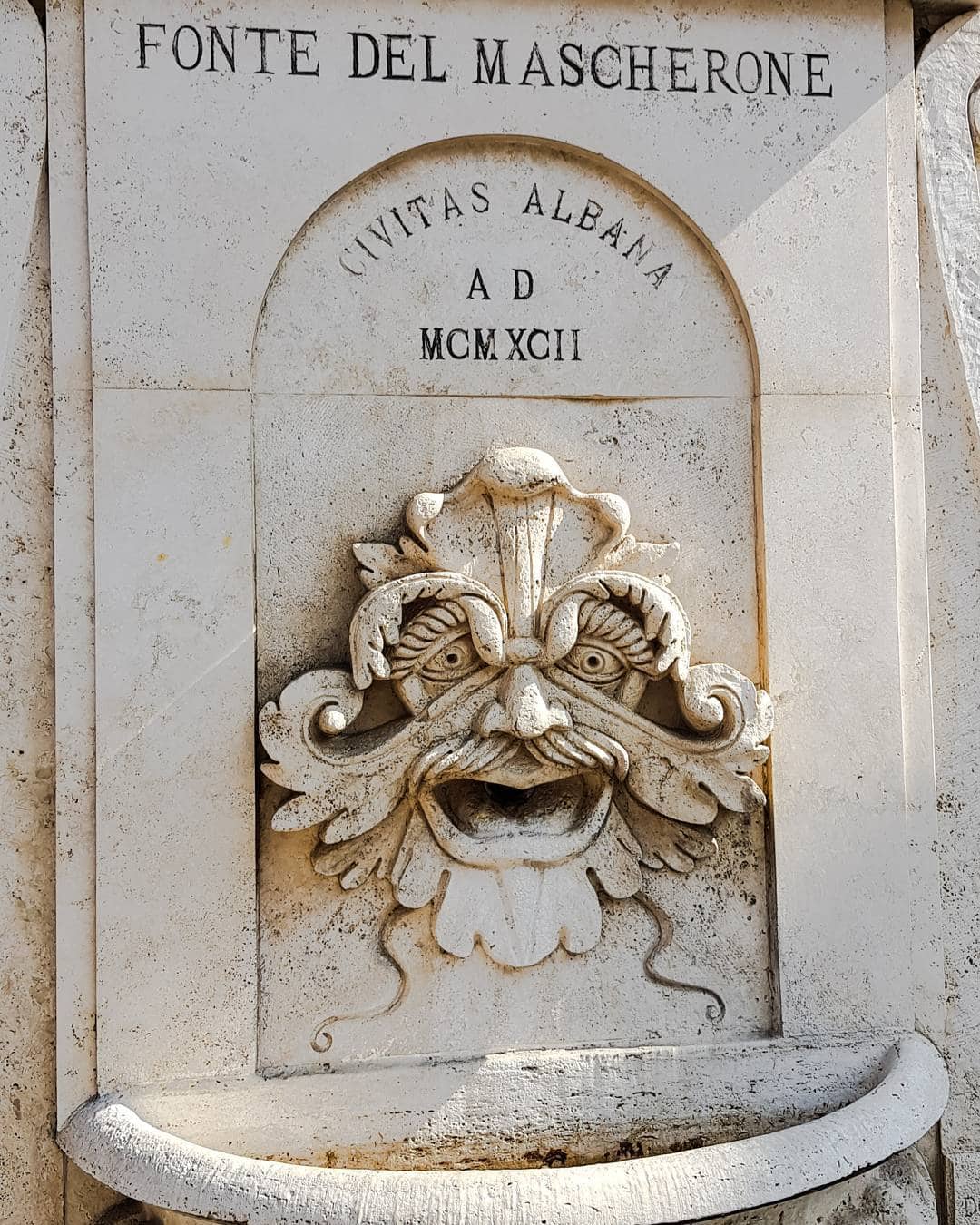 Stone fountain with a decorative face and the inscription "Fonte del Mascherone" above it, a charming sight you might discover during 4 days in Castel Gandolfo.