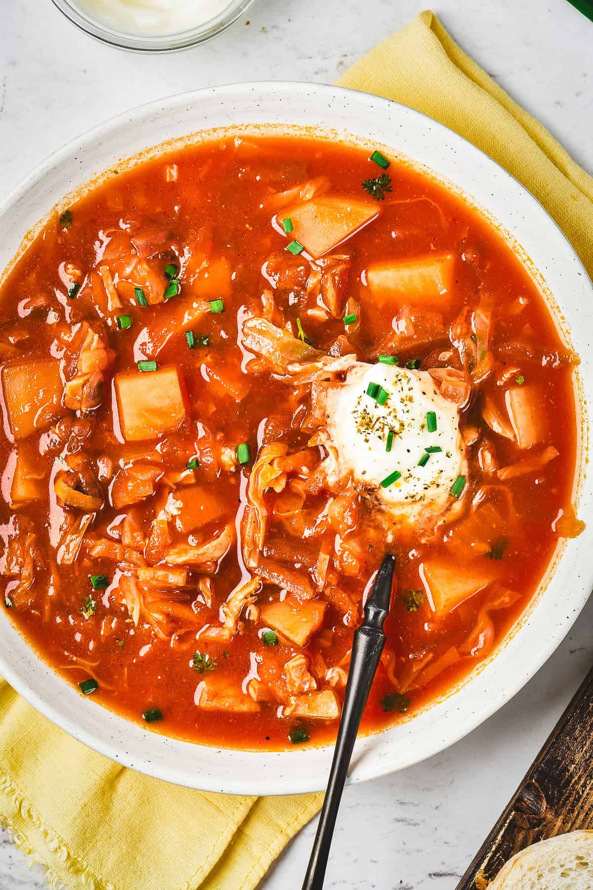 A bowl of borscht soup with potatoes, cabbage, and a dollop of sour cream, garnished with chives&mdash;one of the classic vegetarian dishes in Russia.