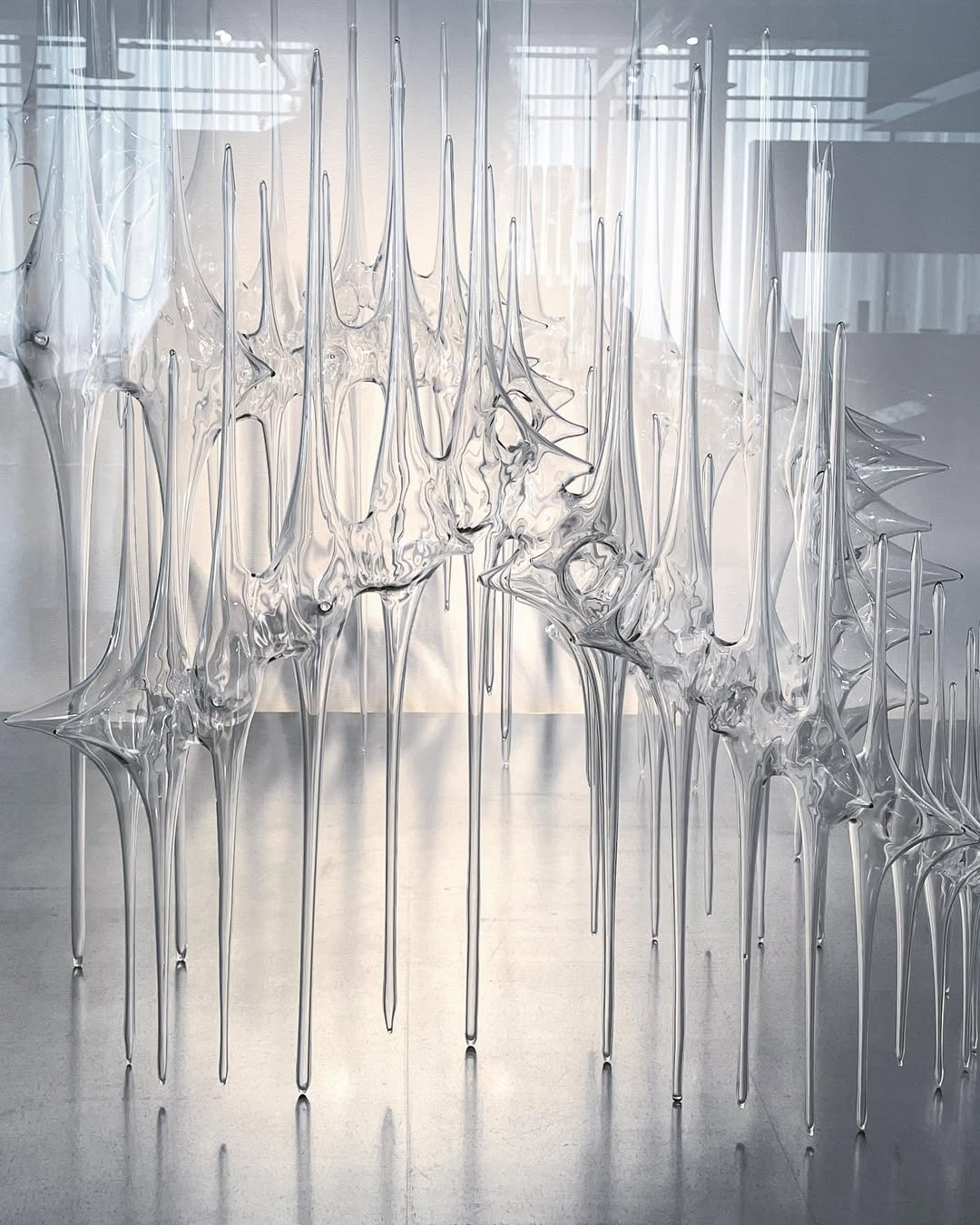 Clear, spiky glass sculpture with elongated points evokes the dramatic beauty of Watkins Glen State Park, displayed in a modern, well-lit gallery space.