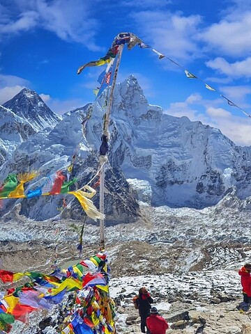 Hikers exploring the snowy peaks of the Himalayas with colorful prayer flags fluttering in the wind.