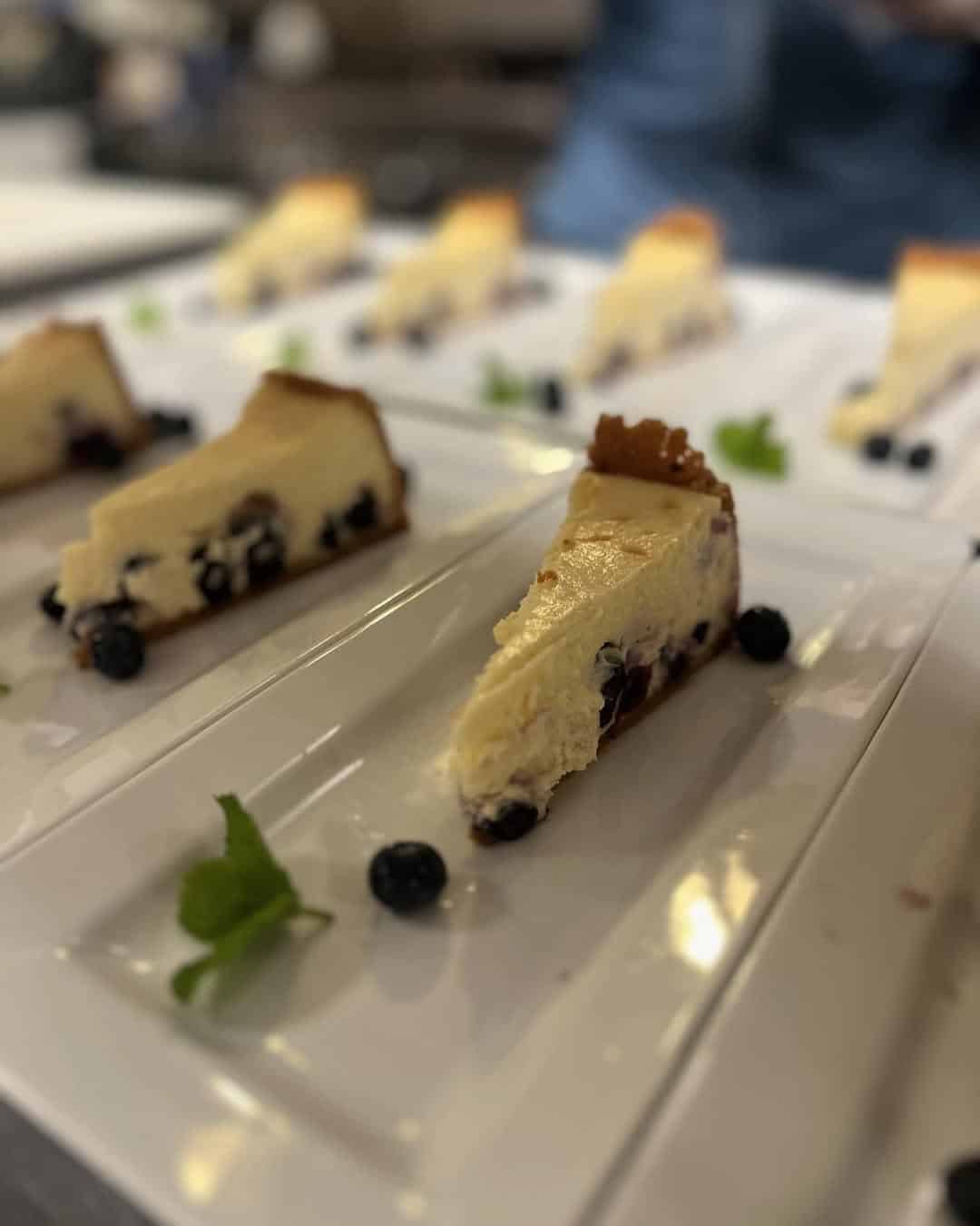 Slices of blueberry cheesecake on white plates, garnished with fresh mint leaves and blueberries&mdash;a delightful dessert often featured at Finger Lakes restaurants and wineries with restaurants.