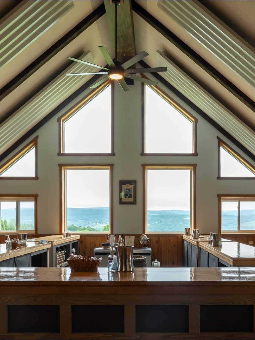 Spacious, modern bar with vaulted ceiling, large windows, mountain view, and natural light streaming in—one of the best places to stay in Finger Lakes near wineries.