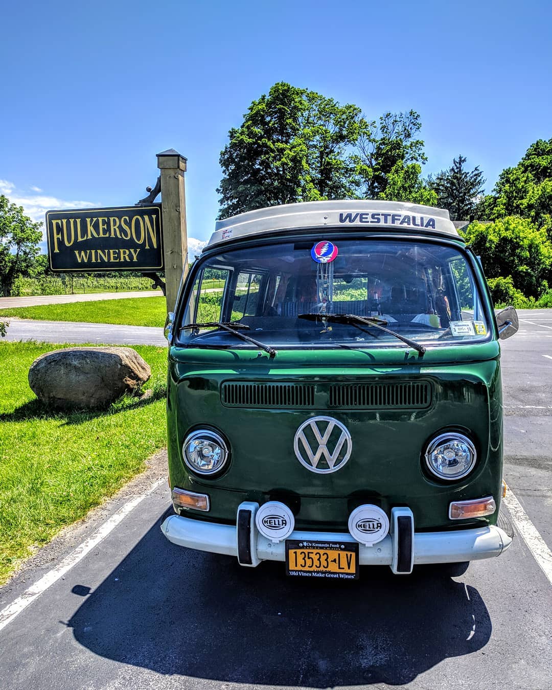 Green Volkswagen van parked near a Fulkerson Winery sign on a sunny day, perfect for exploring Finger Lakes Wine Tours.