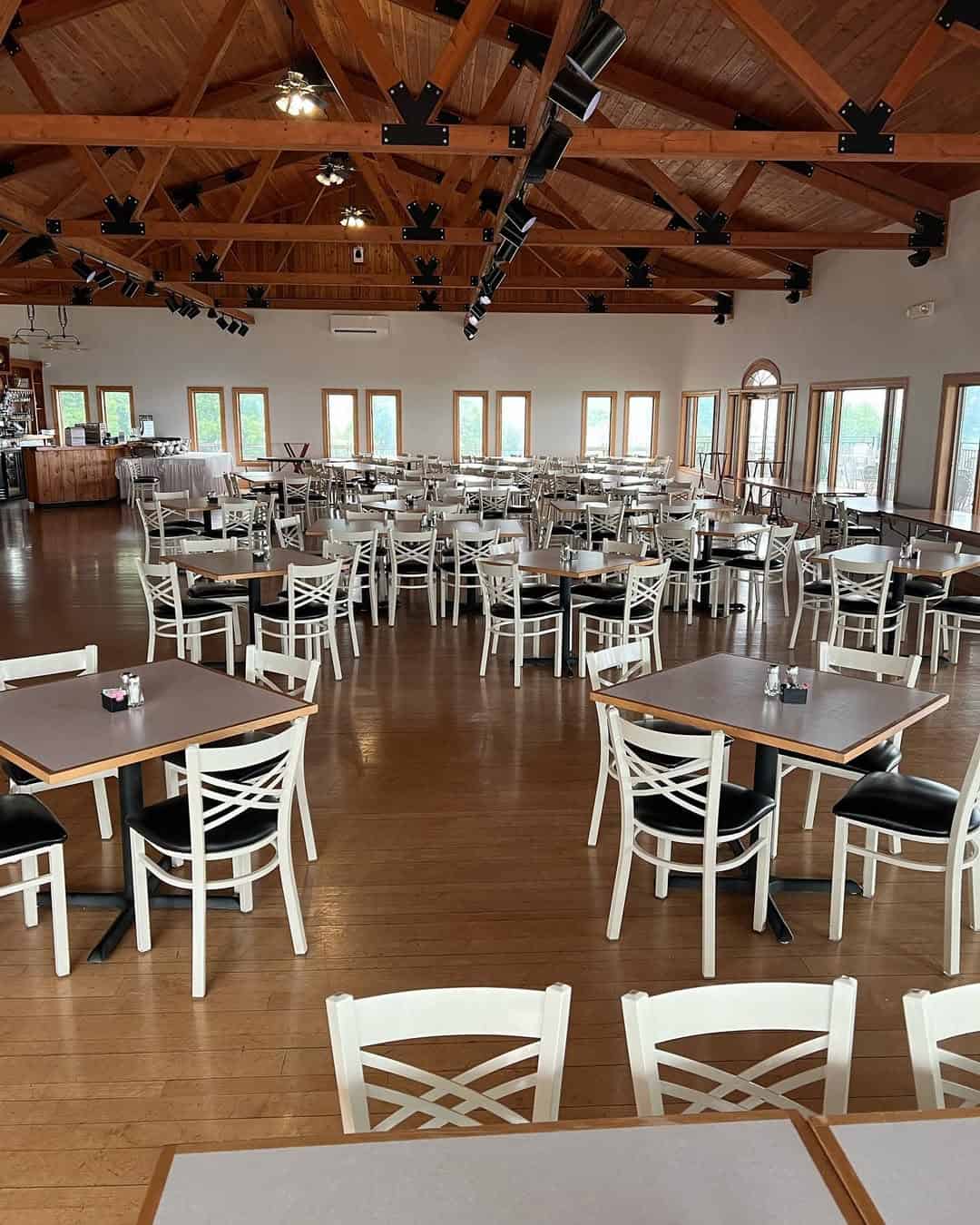 Spacious restaurant with wooden ceiling, empty tables and chairs, large windows letting in natural light&mdash;perfect for those seeking the charm of Finger Lakes wineries with restaurants.